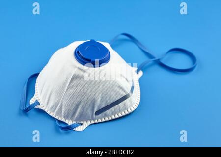 Masque filtrant sur fond bleu. Respirateur N 95. Masque blanc FFP2, protection contre la pandémie de coronovirus COVID-19 Banque D'Images