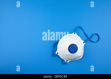 Respirateur N 95. Masque filtrant sur fond bleu avec espace de copie, vue du dessus. Masque blanc FFP2, protection contre le COV du coronovirus Banque D'Images