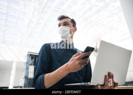jeune blogueur dans le masque de protection regardant par la fenêtre Banque D'Images