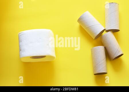Vue de dessus du rouleau de papier toilette et des tubes de papier sur fond jaune. Banque D'Images