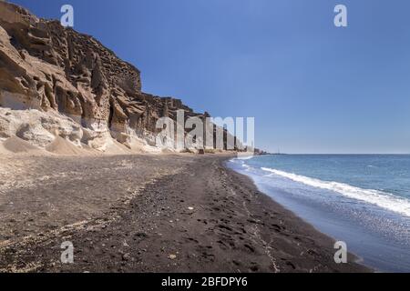 Canyon montagnes et mer avec plage volcanique noire sur Vlychada lors d'une journée d'été ensoleillée avec fond bleu ciel. Île de Santorin, Grèce. Banque D'Images