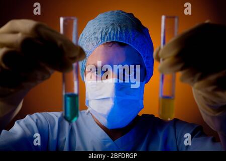 Un technicien de laboratoire qui tient deux tubes à essai contenant chacun un liquide de couleur. Banque D'Images