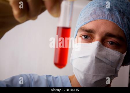 Technicien de laboratoire examinant le contenu liquide d'un tube à essai. Banque D'Images