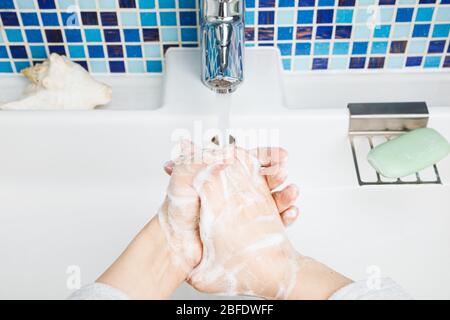 Enfant se laver les mains avec diligence avec du savon antibactérien et de l'eau en réalisant des mesures de protection de base contre la propagation du coronavirus COVID-19 deseas Banque D'Images