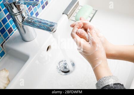 Enfant se laver les mains avec diligence avec du savon antibactérien et de l'eau en réalisant des mesures de protection de base contre la propagation du coronavirus COVID-19 deseas Banque D'Images