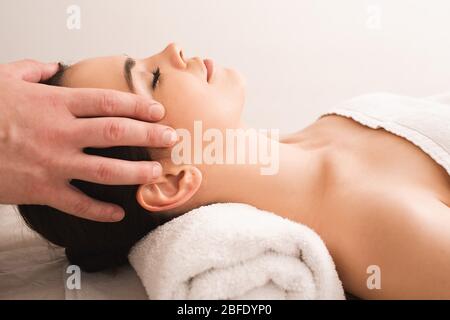 massage relaxant anti-stress de la tête. Belle femme se détend dans un salon de massage pendant un massage Banque D'Images