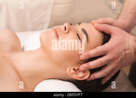 Antistress massage de la tête. Soulager la fatigue et soulager les maux de tête en utilisant le massage oriental. Femme au spa Banque D'Images