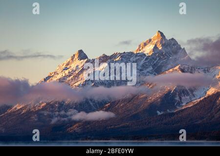 Gamme de montagne couverte de neige et de nuages au lever du soleil de Jackson Lake, parc national de Grand Teton, Wyoming, États-Unis. Banque D'Images