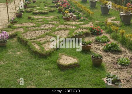 Gros plan de la carte indienne et Sri lankaise faite sur le sol avec boue et frontières avec herbe tissée dans un jardin avec pots de fleurs Banque D'Images