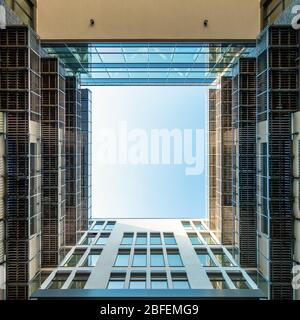 Cour intérieure d'un immeuble de bureaux moderne donnant sur la place en ouvrant sur le ciel bleu le soir Banque D'Images