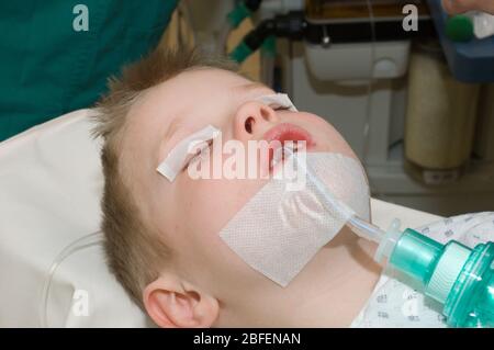 Jeune enfant portant un tube de trachéostomie pendant l'utilisation Banque D'Images