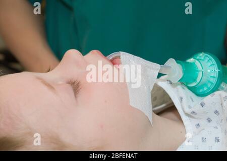 Jeune enfant portant un tube de trachéostomie pendant l'utilisation Banque D'Images