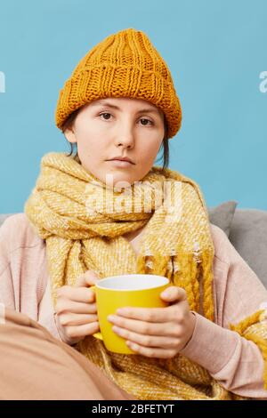 Portrait de la femme malade dans le chapeau de laine et le foulard buvant du thé chaud pour les rhumes Banque D'Images