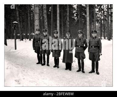 Vintage seconde Guerre mondiale 1940 Adolf Hitler avec les premiers membres de son unité personnelle de garde du corps, le SS Begleit Kommando: Bruno Gesche sur Hitlers immédiatement à gauche, Erich Kempka sur Hitlers immédiatement à droite, Adolf Dirr, août Koerber, Franz Schaedle. Photographié au Lair du loup en hiver au QG du Front oriental en Pologne. Banque D'Images