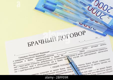 Enregistrement d'un contrat de mariage. Mariage de commodité. Billets de banque roubles, stylo et texte russe du « contrat de mariage » Banque D'Images