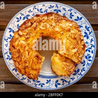 Délicieux gâteau aux pommes et aux amandes maison sur une plaque blanche décorée et un fond en bois Banque D'Images