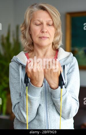 Rester en forme est une façon de vieillir avec grâce. Exercice de femme mature à la maison.entraînement de biceps. Banque D'Images