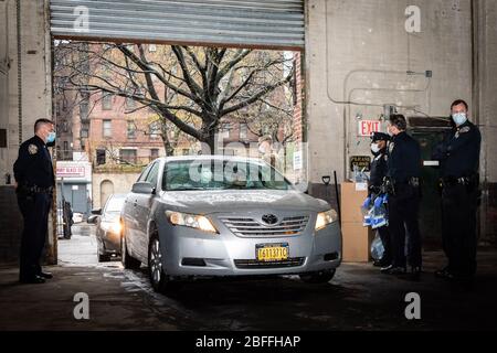 Bronx, États-Unis d'Amérique . 18 avril 2020. Les membres du département du shérif de New York donnent des instructions aux conducteurs de taxi de l'Armory de Kingsbridge dans le Bronx le 18 avril 2020. L'armory est utilisé comme centre temporaire de distribution alimentaire pendant la crise de COVID-19 et les soldats de l'armée américaine chargent des repas dans les cabines des chauffeurs titulaires de permis de CCM qui les livrent aux New Yorkers dans le besoin pendant la pandémie de COVID-19. (Photo de Gabriele Holtermann-Gorden/Sipa USA) crédit: SIPA USA/Alay Live News Banque D'Images