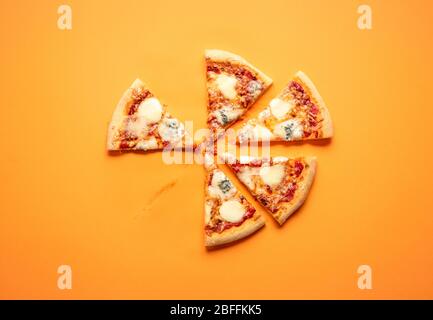 Vue de dessus avec des tranches de pizza sur fond orange. Plat avec une pizza en tranches. Pizza végétarienne faite avec quatre types de fromage et sauce tomate Banque D'Images