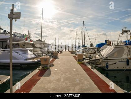 Vue rétro-éclairée sur des rangées de yachts de luxe amarrés à un quai dans le port touristique 'Portosole' ('Port du ') de Sanremo, Imperia, Ligurie, Italie Banque D'Images