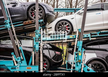Vestal, NY/USA - 11 avril 2020 : une remorque semi-tracker transportant sept modèles Tesla 3 et X, peinte en blanc, noir et argent, est garée la nuit Banque D'Images