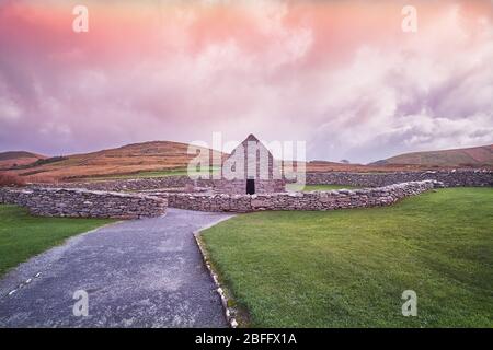 Coucher de soleil vue tard en soirée avec beau rose de la tombe Oratoire de Gallarus dans la péninsule de Dingle sur le comté de Wild Atlantic Way Kerry Irlande Banque D'Images