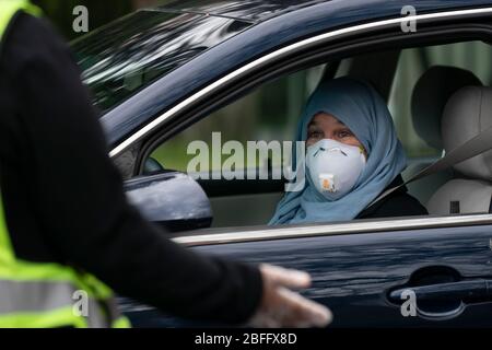 Falls Church, Virginie, États-Unis. 18 avril 2020. Un donateur parle avec un volontaire lors d'un événement de don de transfert en voiture le samedi 18 avril 2020 à la mosquée Dar Al-Hijrah de Falls Church, en Virginie. La mosquée distribue les dons à ceux qui en ont besoin pendant la pandémie COVID-19. Crédit: Sait Serkan Gurbuz/ZUMA Wire/Alay Live News Banque D'Images