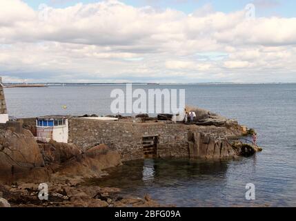 Nageurs en mer irlandaise à la quarante pieds historique à Sandycove Banque D'Images