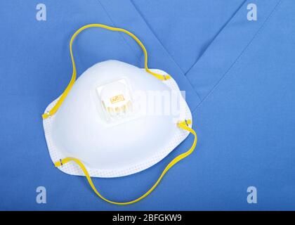 Vue du dessus, couche plate d'un masque de qualité médicale N 95 posé sur un uniforme de nettoyage supérieur. Banque D'Images