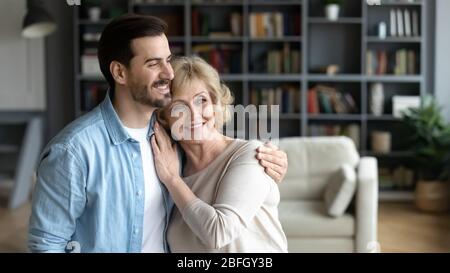 Intérieur d'une chambre confortable embrassant la mère âgée et le fils grogner Banque D'Images