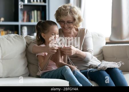 Grand-mère senior enseigne à la petite petite petite-fille à tricoter Banque D'Images