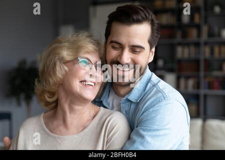 Mère âgée et fils grogner embrassant rire profiter du temps ensemble Banque D'Images