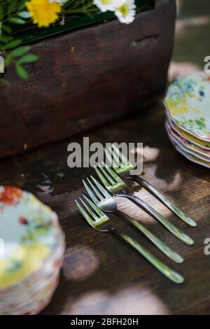 Les fourches sont placées côte à côte sur une table en bois et flanquées de petites plaques. Banque D'Images