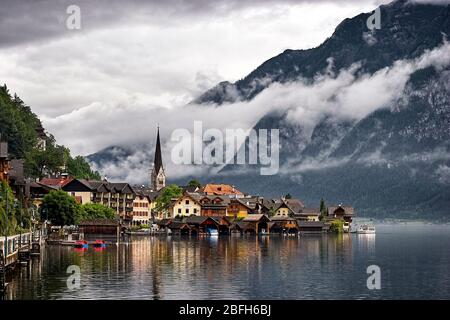 Nuages bas penchant sur le village de Hallstatt et les montagnes environnantes. Hallstatt, Salzkammergut, Autriche. Banque D'Images