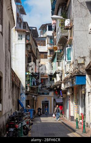 Les gens marchent dans une rue étroite dans le centre historique de Macao, en Chine. Banque D'Images