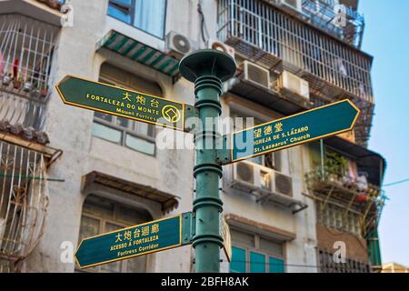 Pole avec des panneaux indiquant la forteresse du Mont et d'autres attractions du quartier historique de Macao, Chine. Banque D'Images