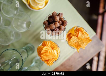 Des collations sont servies sur la table côte à côte avec un verre vide et des tranches de citron. Banque D'Images