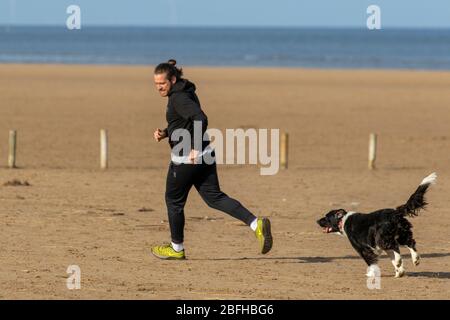 Southport, Merseyside. Météo britannique. 19 avril 2020. Une autre journée ensoleillée d'avril au printemps dans la station balnéaire, alors que les habitants de la région font de l'exercice léger sur les vastes sables côtiers de la plage nord-ouest d'Ainsdale. Le ministre Michael Gove a déclaré qu'il était trop tôt pour lever les restrictions sur les mouvements de personnes et les règles de distanciation sociale, il faut continuer à s'appliquer pendant un certain temps. Crédit: MediaWorldImages/AlamyLiveNews Banque D'Images