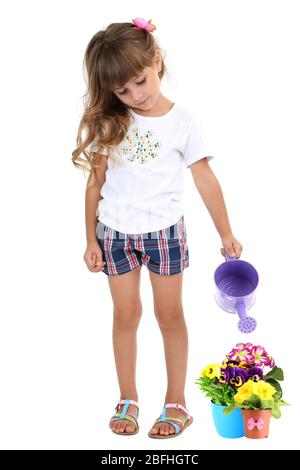 Petite fille arrosant de belles fleurs isolées sur blanc Banque D'Images