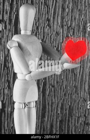 Mannequin en bois holding red heart Banque D'Images