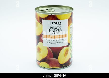 Irvine, Écosse, Royaume-Uni - 18 avril 2020: Étain de moitiés de Peach de marque Tesco dans des boîtes et étiquettes en papier recyclables Banque D'Images