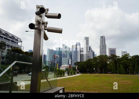 Pôle avec caméras de vidéosurveillance intelligentes dans un parc de Singapour avec gratte-ciel en arrière-plan, Singapour Banque D'Images