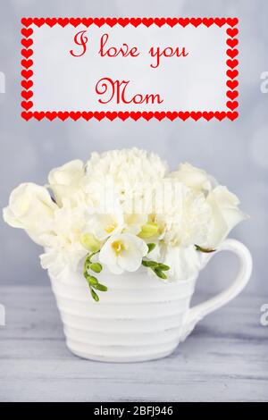 Magnifique bouquet de fleurs de freesia en tasse sur table en bois Banque D'Images