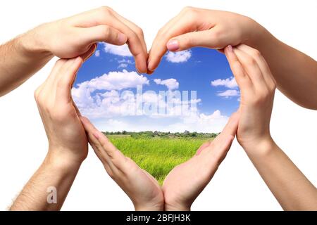 Beau champ dans le coeur formé par des mains mâles et femelles isolées sur blanc Banque D'Images