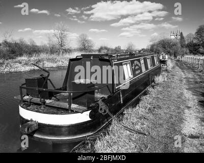 Paysage noir et blanc de la barque sur le canal de Kennet et Avon, avec l'église Saint-Laurent, Hungerford, Berkshire, Angleterre, Royaume-Uni, GB. Banque D'Images