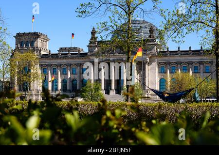 19 avril 2020: Les gens aiment le soleil dans un hamac devant le Reichstag allemand. Les gens aiment le soleil à l'intérieur d'un peuple vivant dans la ville de Berlin doivent rester dans leurs appartements ou l'hébergement habituel pour contenir le coronavirus, les réunions de plus de 2 personnes sont interdites, les restrictions de contact seront maintenues avec une distance minimale de 1,5 mètres. En même temps, le Gouvernement fédéral et les Etats fédéraux ont convenu d'un assouplissement prudent des restrictions à la vie quotidienne, les magasins avec une zone de vente de 800 mètres carrés peuvent rouvrir à Arpil, le 20 sous certaines conditions Banque D'Images