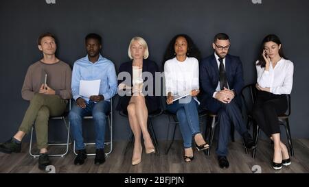 Divers candidats au travail attendent dans la file d'attente avant l'entrevue Banque D'Images