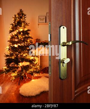 Porte ouverte avec sapin de Noël décoré dans la chambre Banque D'Images