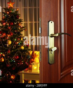 Porte ouverte avec sapin de Noël décoré dans la chambre Banque D'Images