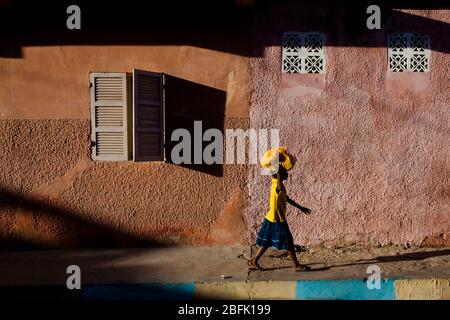 La jeune fille progresse dans le vieux quartier de Saint Louis, au Sénégal. Banque D'Images